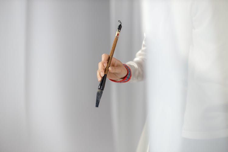 Close Up Photo Of A Person Holding Ink Brush