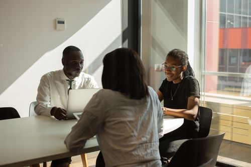 Free Three professionals engaged in a productive meeting in a sunlit office space. Stock Photo