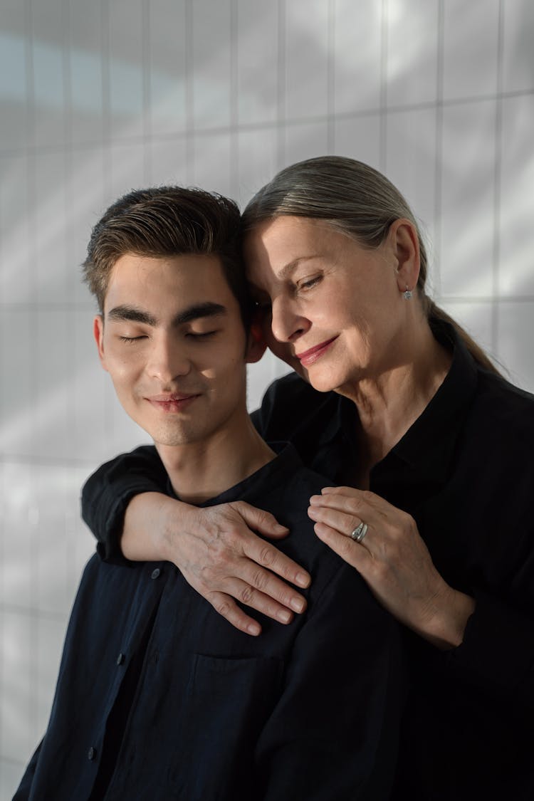 A Woman Embracing A Man In Black Long Sleeves