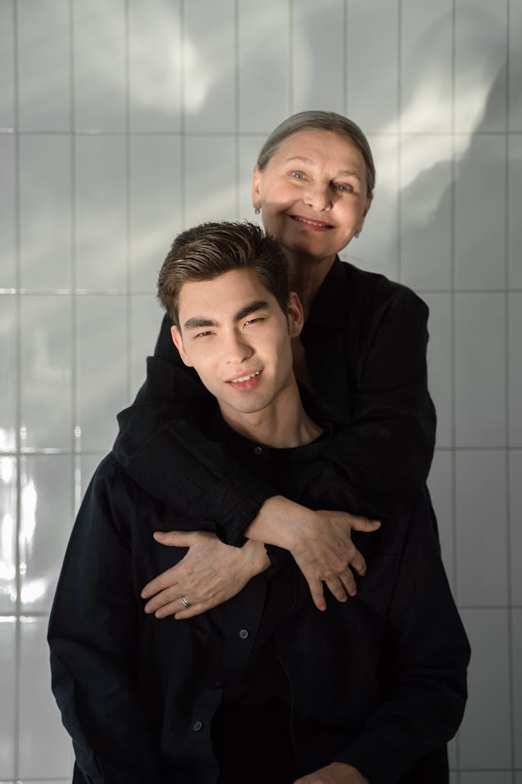 A Woman Embracing A Man In Black Long Sleeves