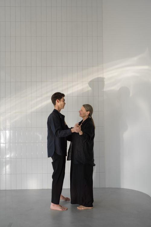 Free A man and elderly woman share a tender dance in a minimalist indoor space. Stock Photo