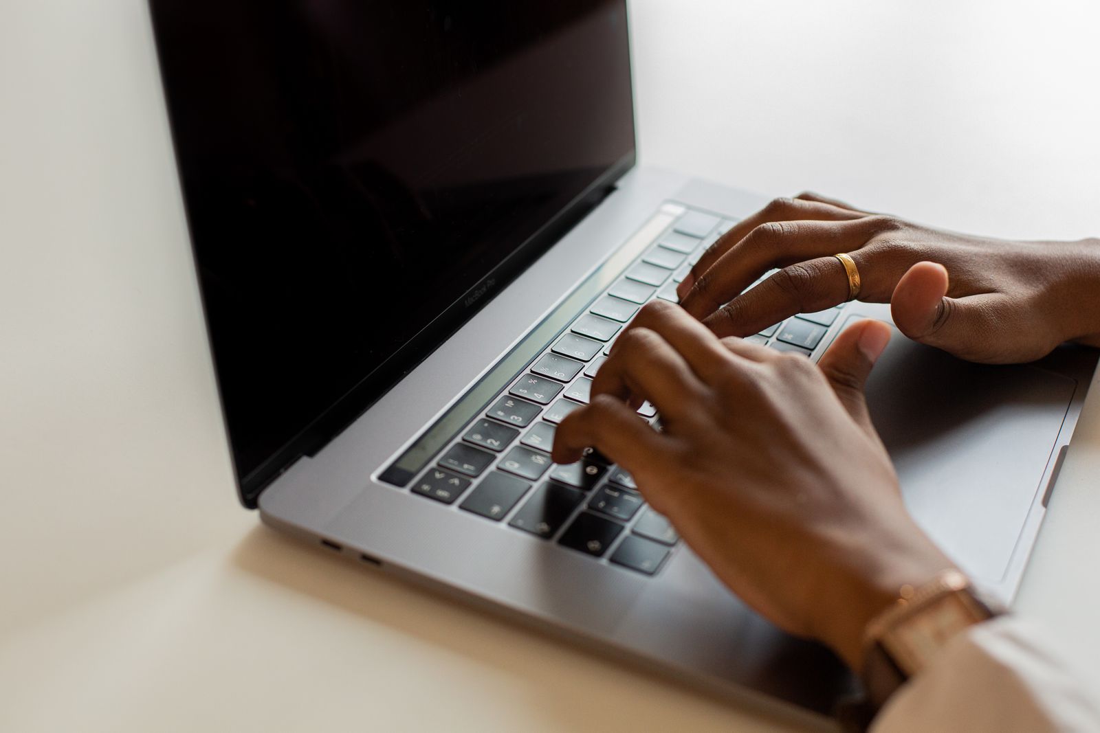 Bright desk setup with hands typing on a laptop keyboard