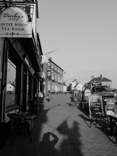 Black and white photo of Ironbridge, England showcasing a quaint street with a historic tea room.