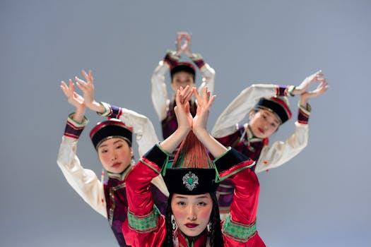 Four women perform a traditional Mongolian dance in elaborate ethnic costumes in a studio setting.
