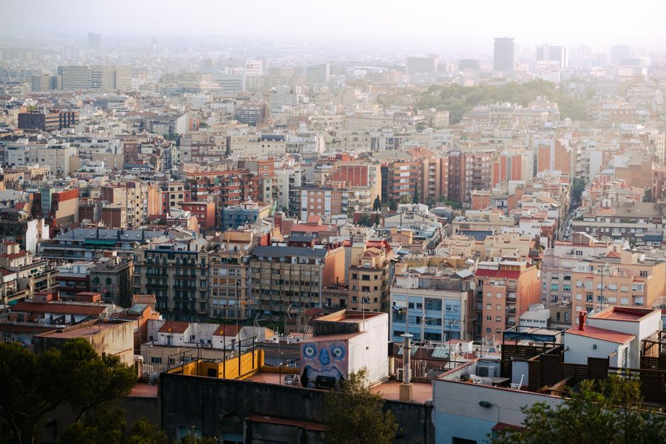 Vista aérea expansiva de Barcelona, mostrando una arquitectura diversa y una vibrante vida urbana.