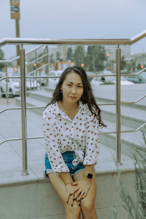 Gratis stockfoto met Aziatische vrouw, balustrade, handen op de knieën
