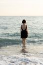 Woman in Black Spaghetti Strap Dress Standing on Beach