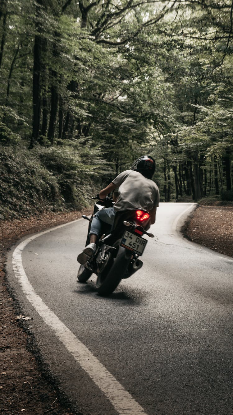 Man Wearing Helmet Riding Motorcycle On Road