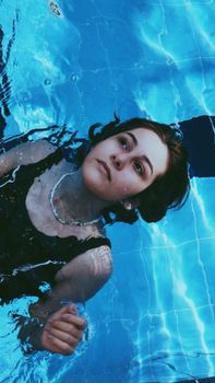 A serene woman floating in a pool, embracing relaxation.