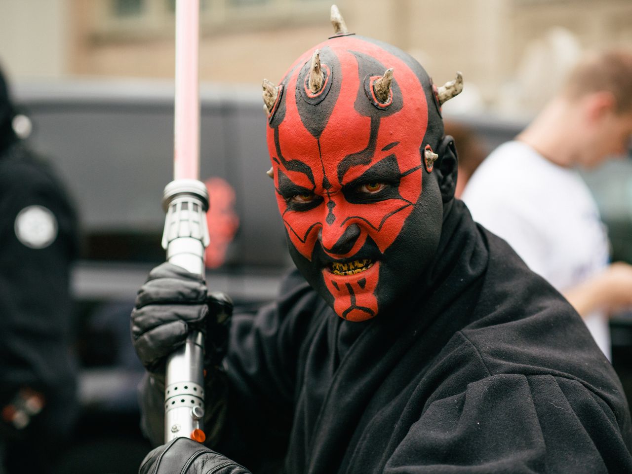 close up portrait of a cosplayer dressed as a sith lord with a lightsa