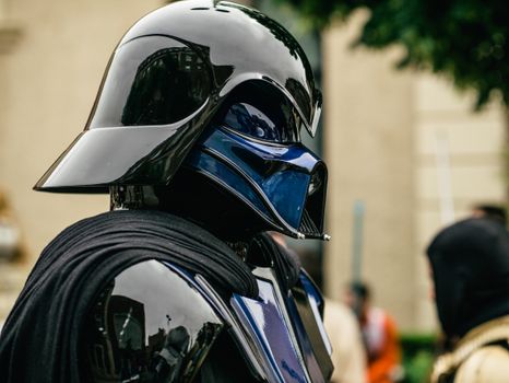 Detailed side view of a cosplayer dressed as Darth Vader at an event.