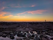 日落时分，宁静的海滩上有人在漫步