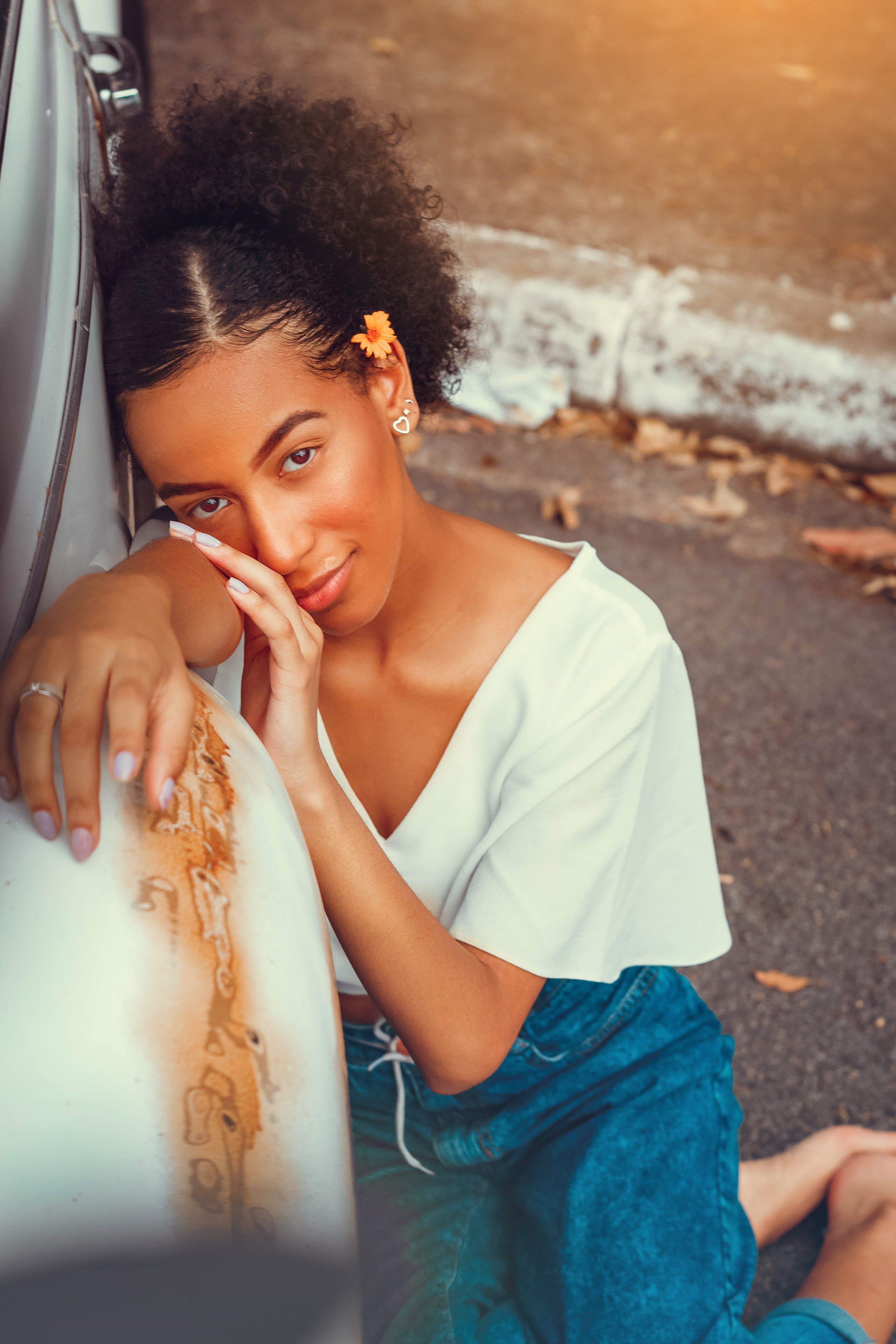 Woman in White Sweater Sitting on Steel Railing · Free Stock Photo