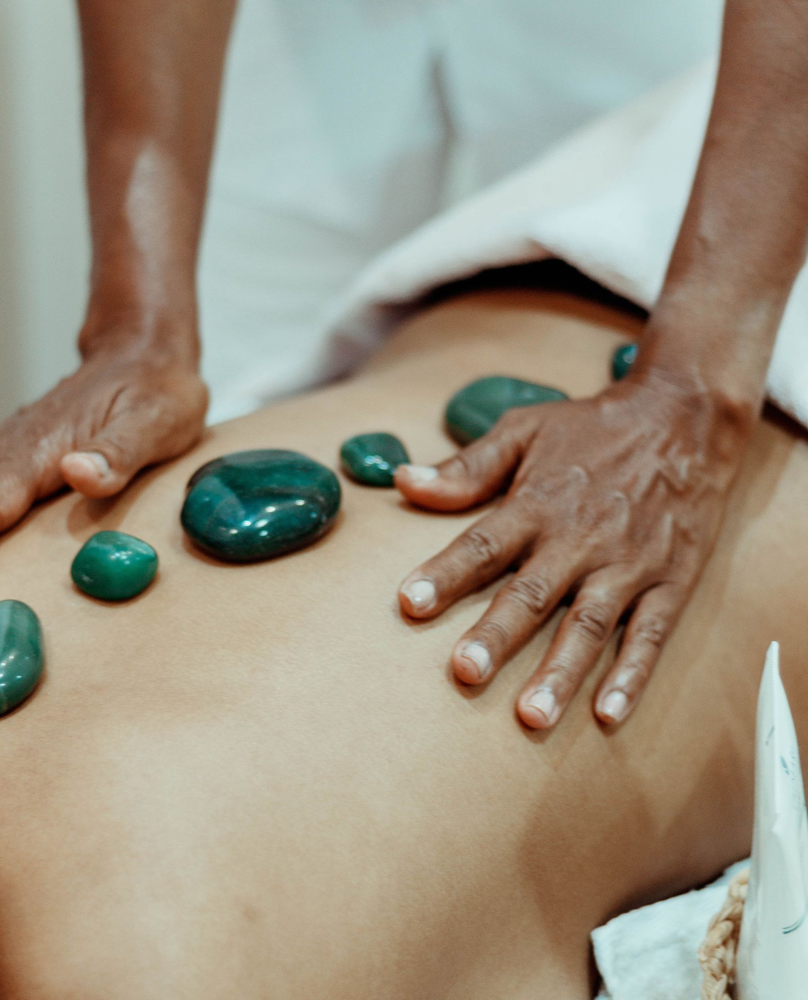 A therapist’s hands performing a soothing hot-stone massage
