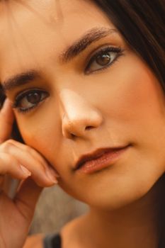 Intimate close-up portrait of a woman with hand on face, showcasing natural beauty.