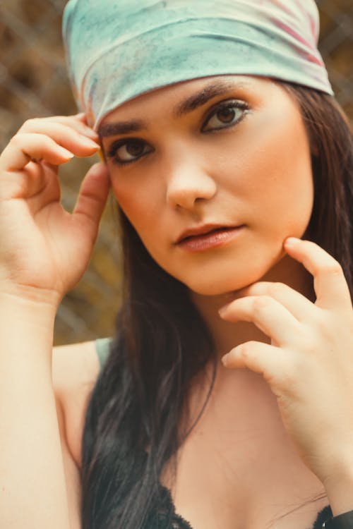 Woman Wearing a Bandana with Hand on Cheek