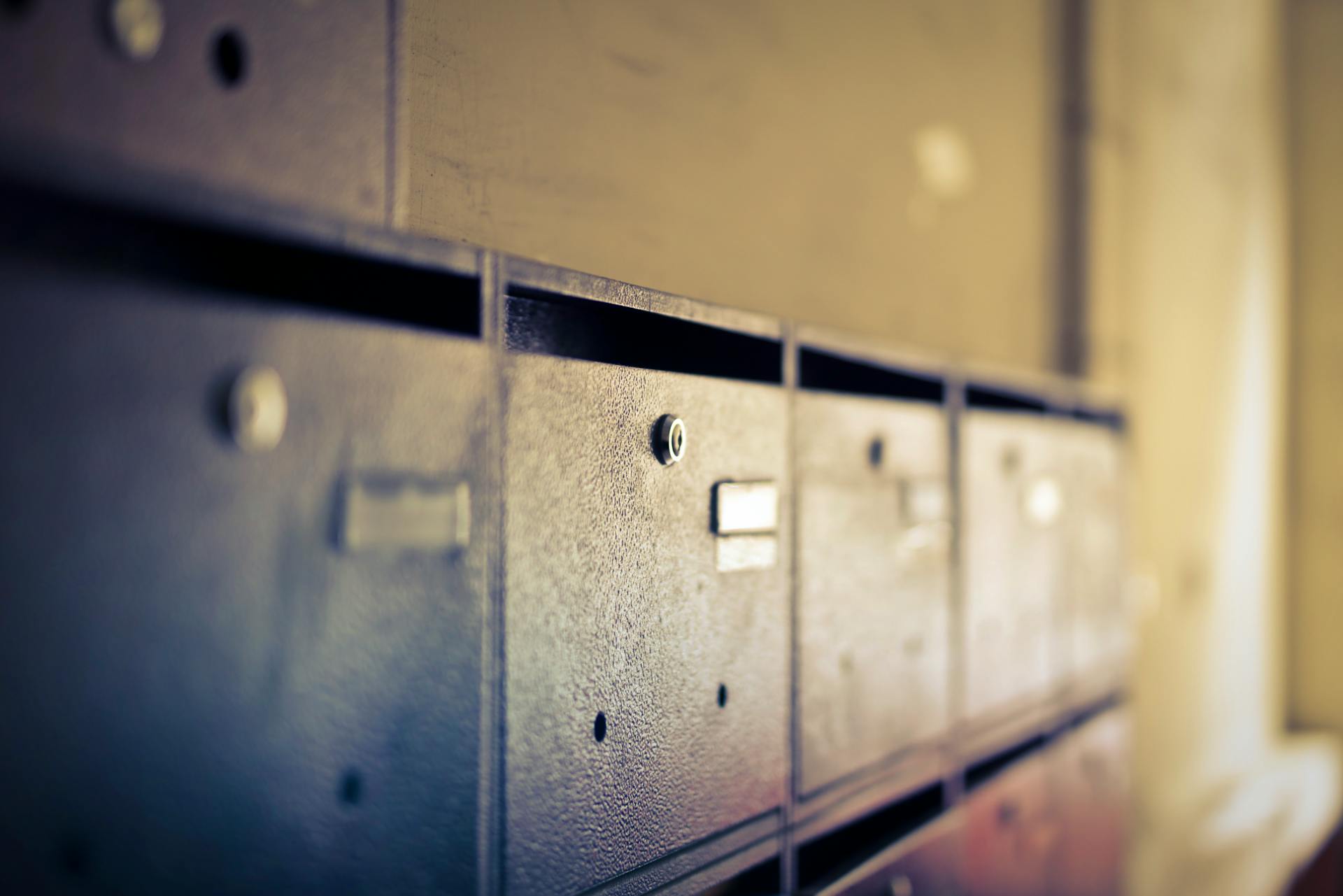 A close-up shot of vintage metal mailboxes indoors with a soft blur effect.