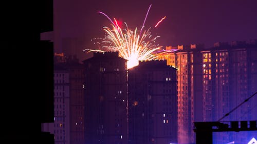 야간 고층 빌딩 근처의 불꽃 놀이