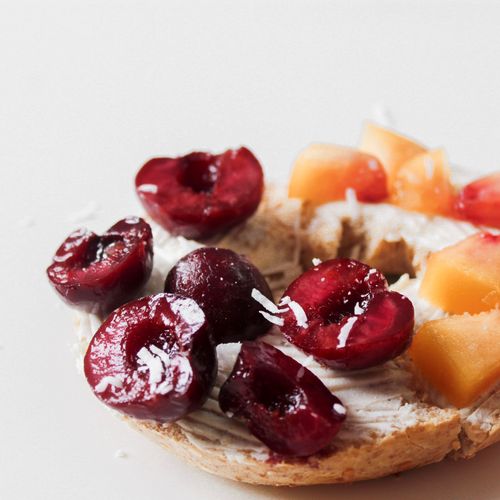 Free Close-up of a bagel topped with cream cheese, cherries, and peaches, perfect for a breakfast treat. Stock Photo