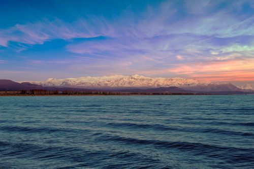 Free Capture the serene beauty of Perito Moreno Glacier with snow-capped mountains and a vibrant sky at sunset. Stock Photo