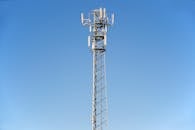 晴朗的蓝天下，一座高耸的手机塔映衬着现代通信技术