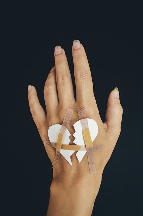 Free A Hand with a Broken Heart Paper  Stock Photo