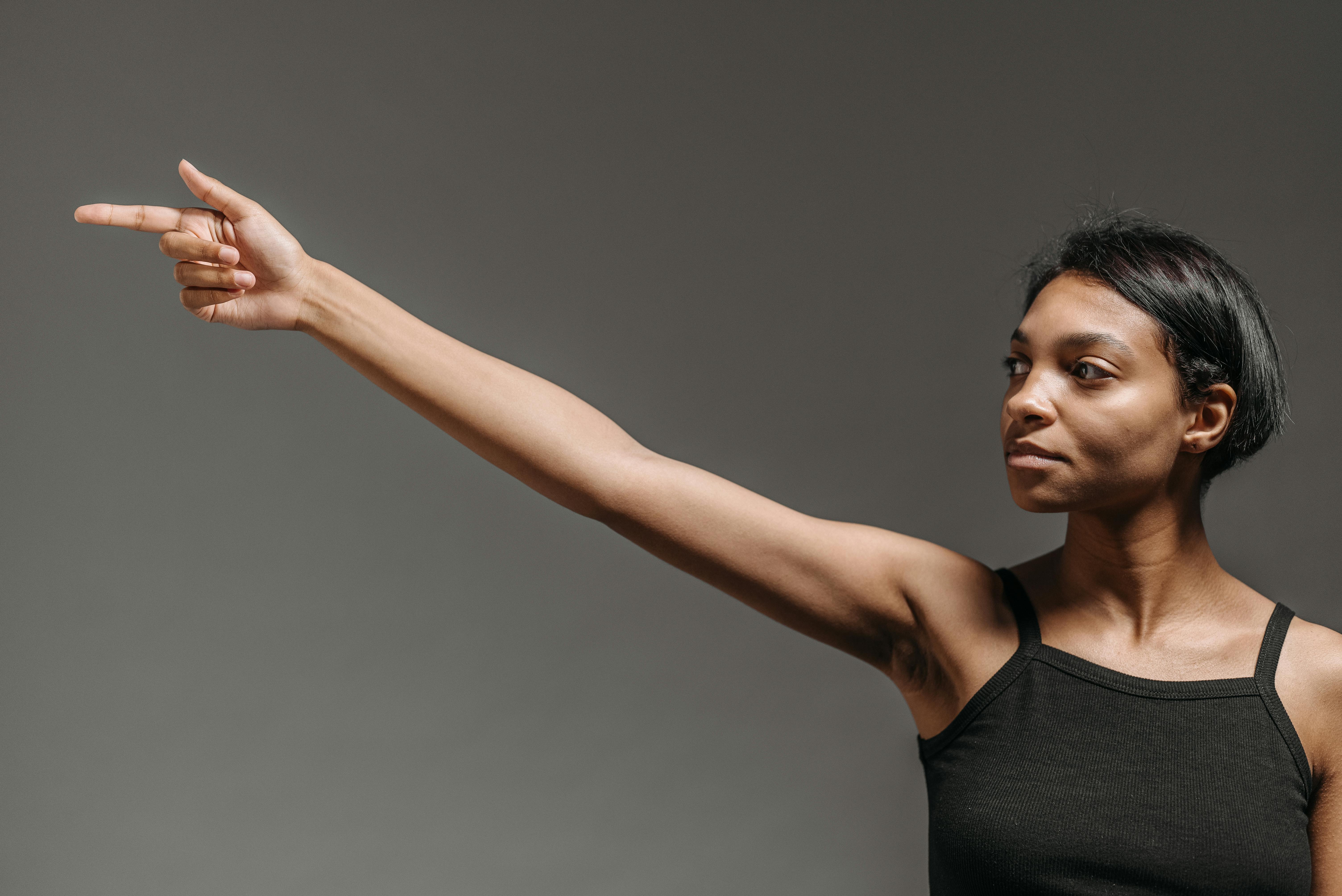 woman in black tank top raising her right hand