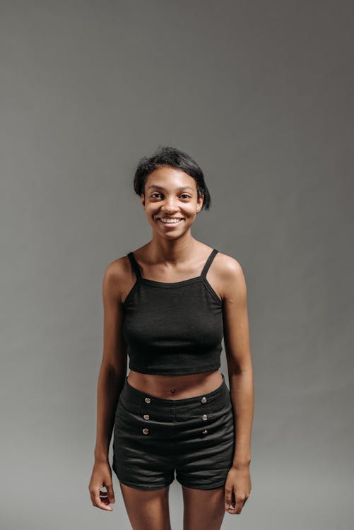 A Cheerful Woman in a Black Tank Top and Shorts