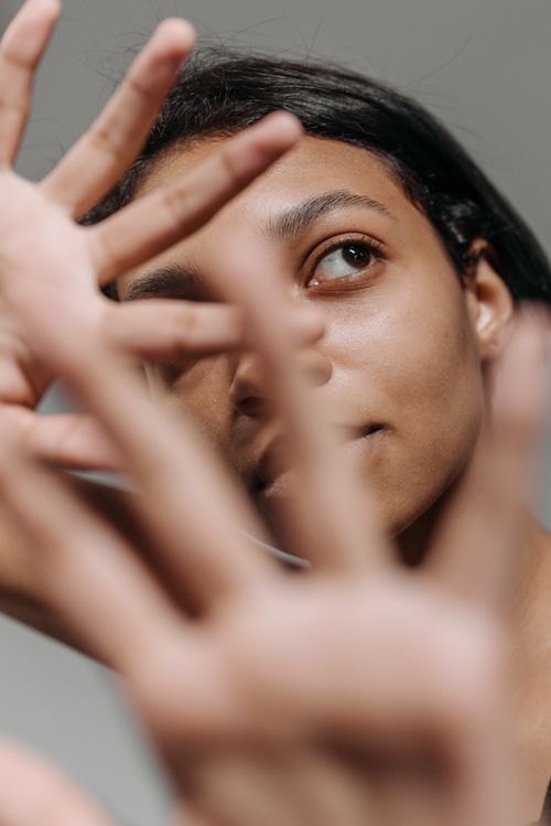 Free Close-up portrait of a woman with hands strategically positioned, creating an artistic and introspective mood. Stock Photo