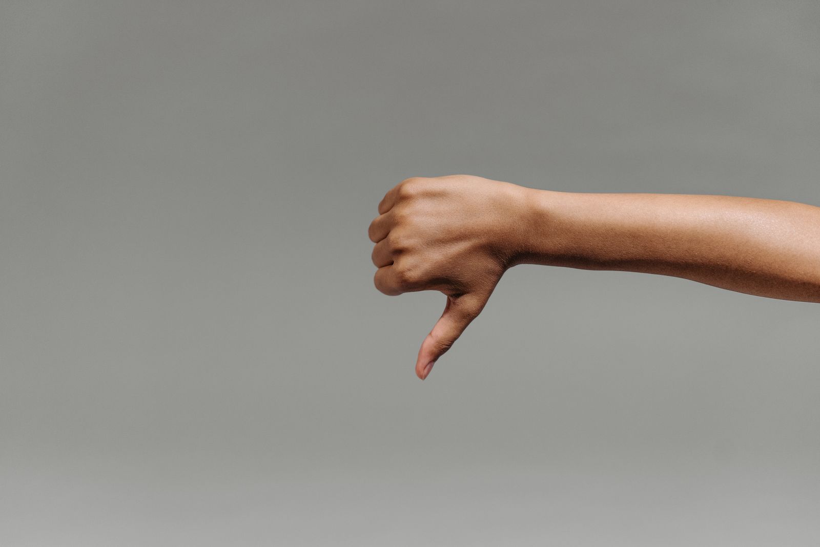 Person holding and checking their thumb and wrist in bright natural light