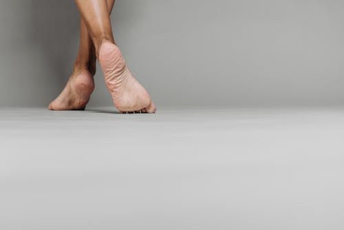 Barefoot Person Standing on White Floor