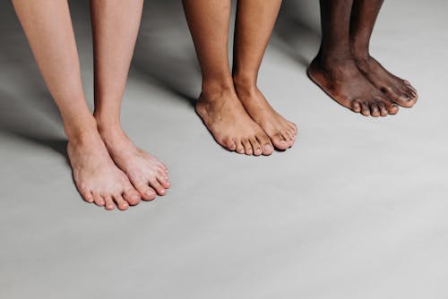 Free Close Up Photo of People Standing on Gray Surface Stock Photo