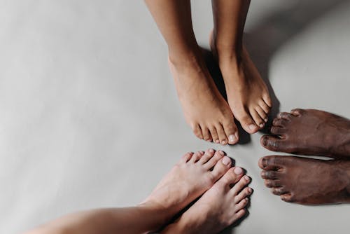 Barefooted People Standing on a White Surface