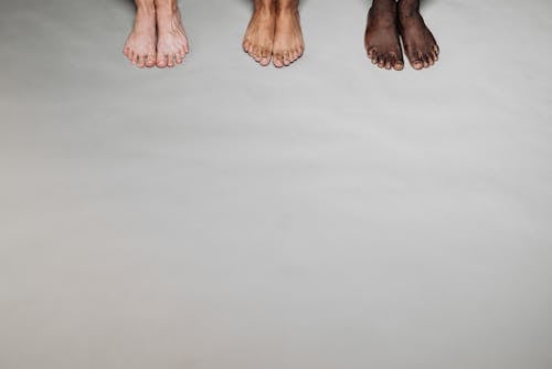 Barefooted People Standing Together on a White Surface