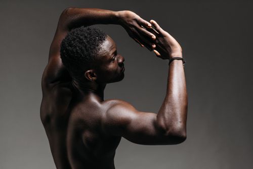 Free A fit man strikes a dynamic pose in a studio setting, showcasing strength and flexibility. Stock Photo