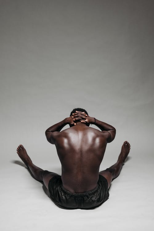 Back View of a Man Sitting on the Floor 