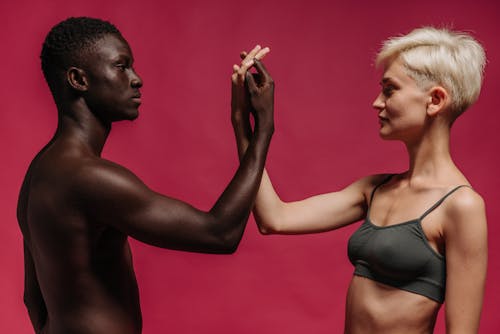 Man and Woman Facing Each Other While Touching Their Hands 