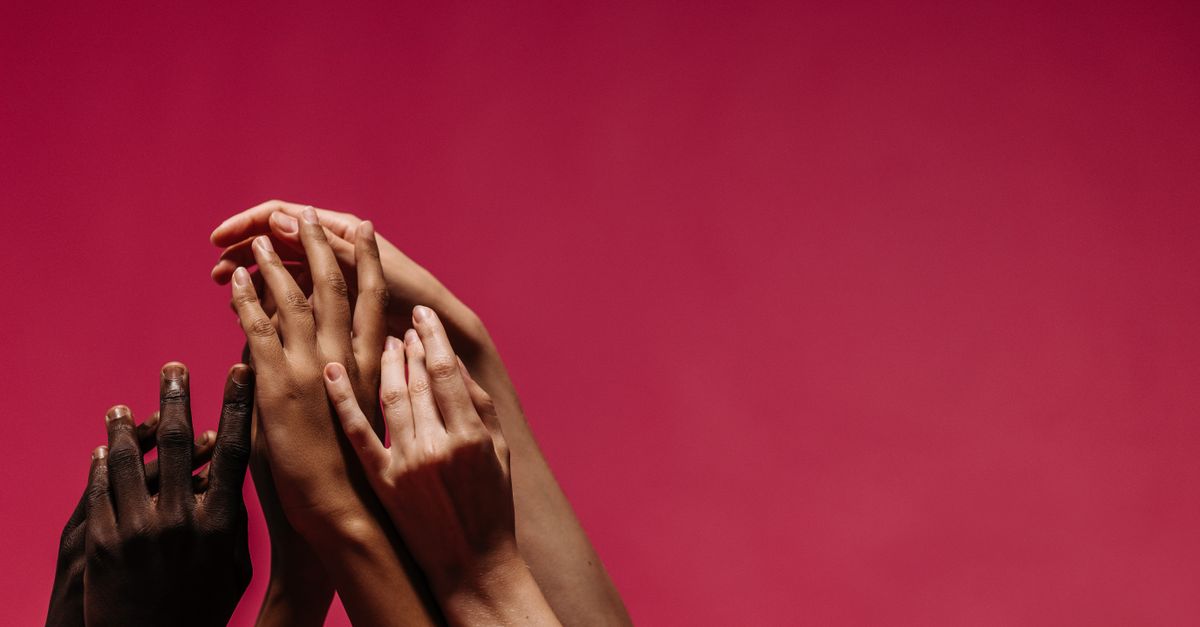 A diverse group of hands reaching upwards on a vibrant pink background symbolizing unity and diversity. - Evidence evidence guide for lactoferrin skin support randomized trial