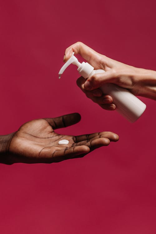 Person Holding White Plastic Bottle of Soap