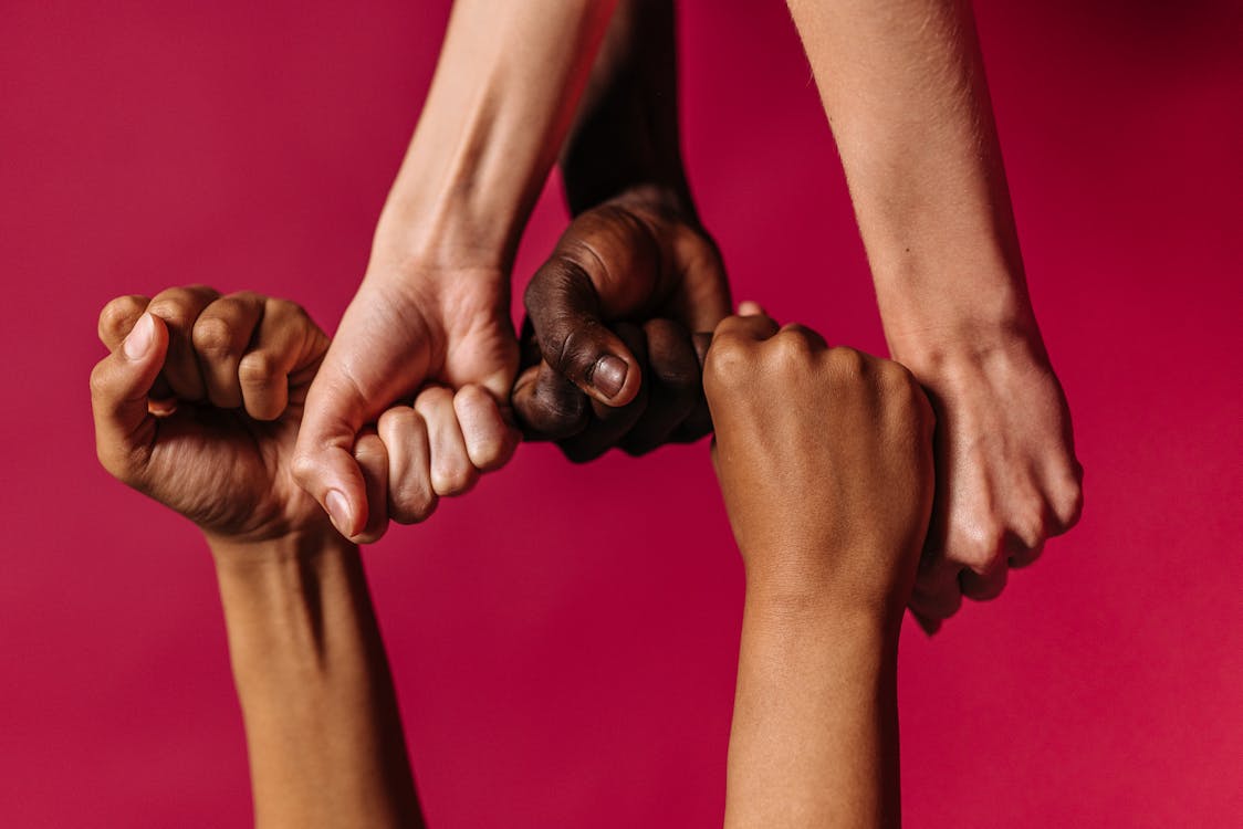 Fist Hands of People in Pink Background