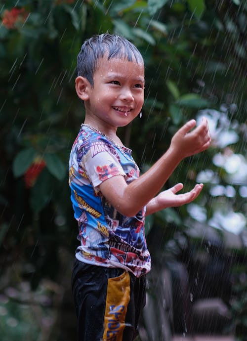 Free Photo of a Cute Kid Playing in the Rain Stock Photo