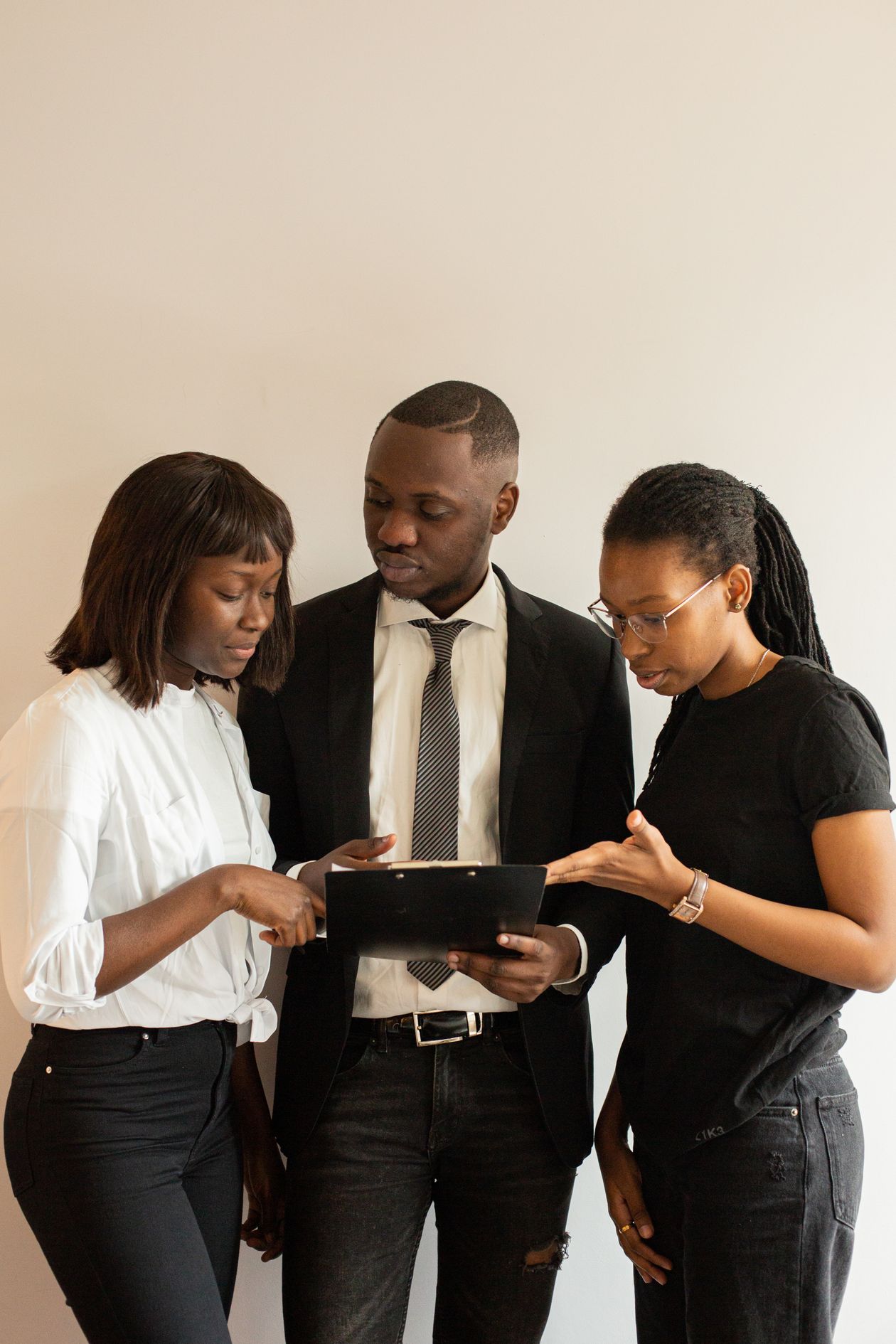 Three African colleagues reviewing work together on a tablet in an office