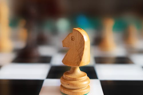 Selective Focus Photo of a Wooden Knight Chess Piece