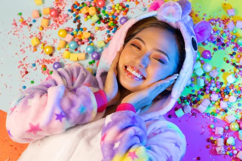 Woman Wearing Costume Lying Beside Candies