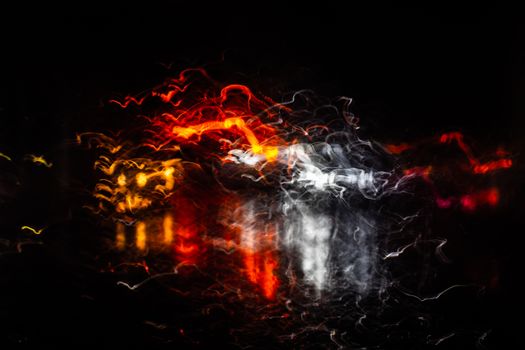 Creative capture of vibrant light trails against a dark night sky, showcasing abstract motion and colors.