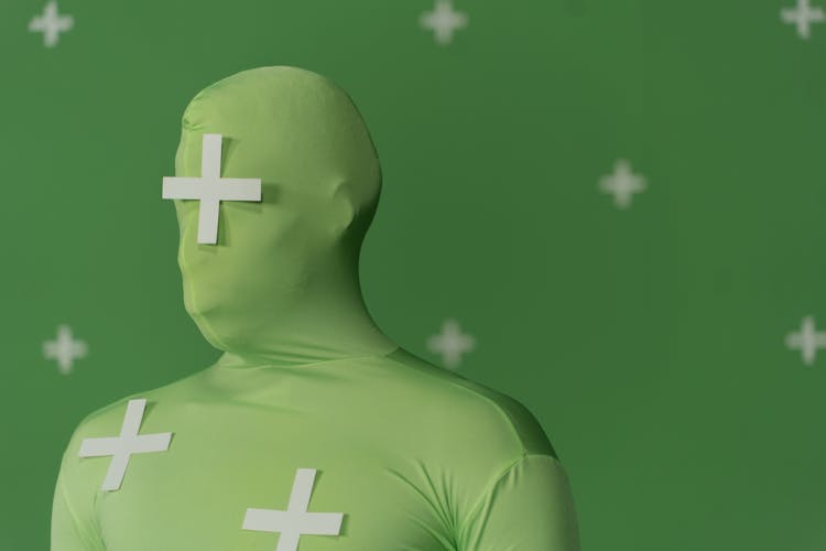 White Plus Symbols On Person In Green Suit