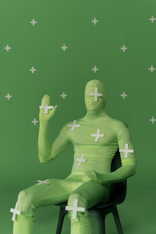 A Man in Zentai Costume Sitting on a Chair