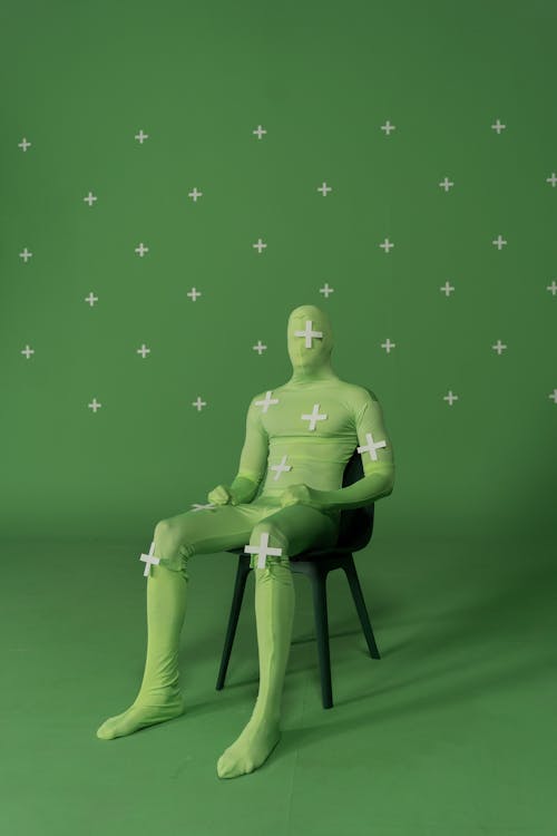A Person in Color Green Costume Sitting on a Chair
