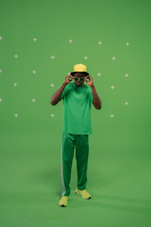 Man in Green Shirt and Green and White Pants Wearing Yellow Bucket Hat