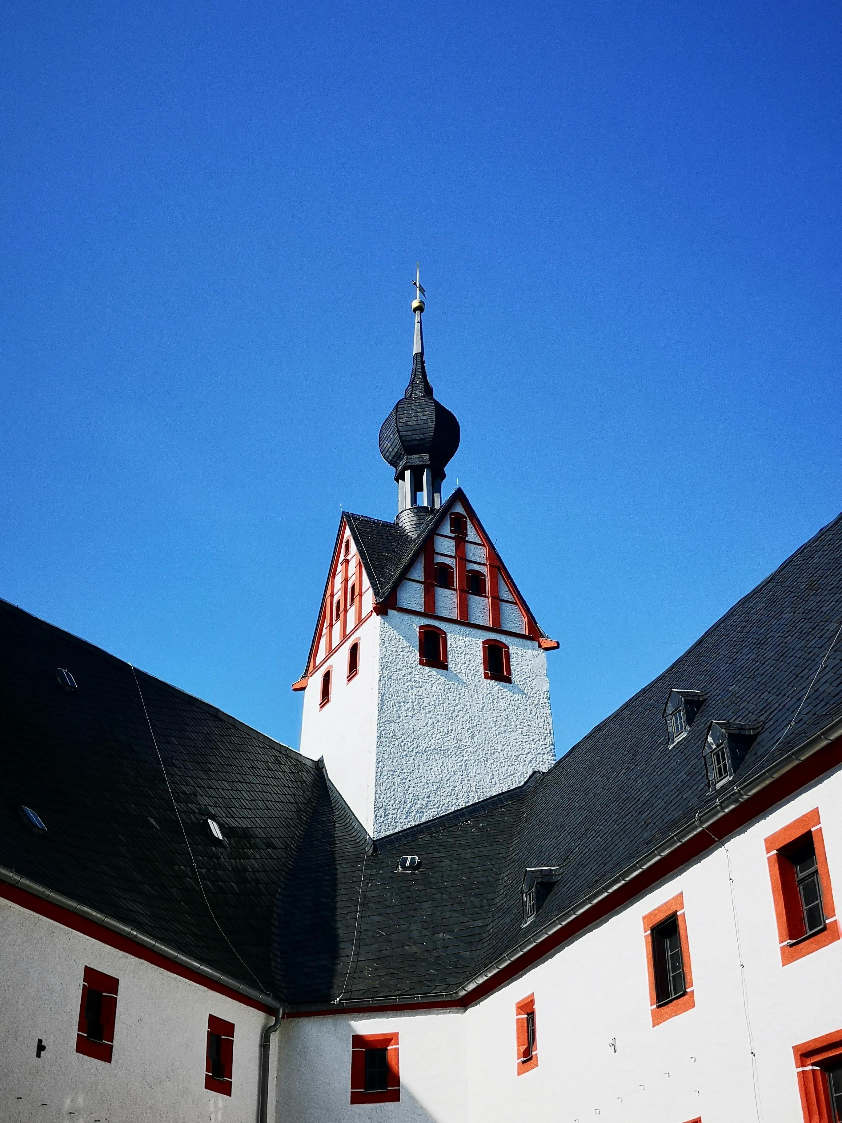 Low angle view of the gothic tower at Rochsburg Castle against a blue sky in Lunzenau, Germany.